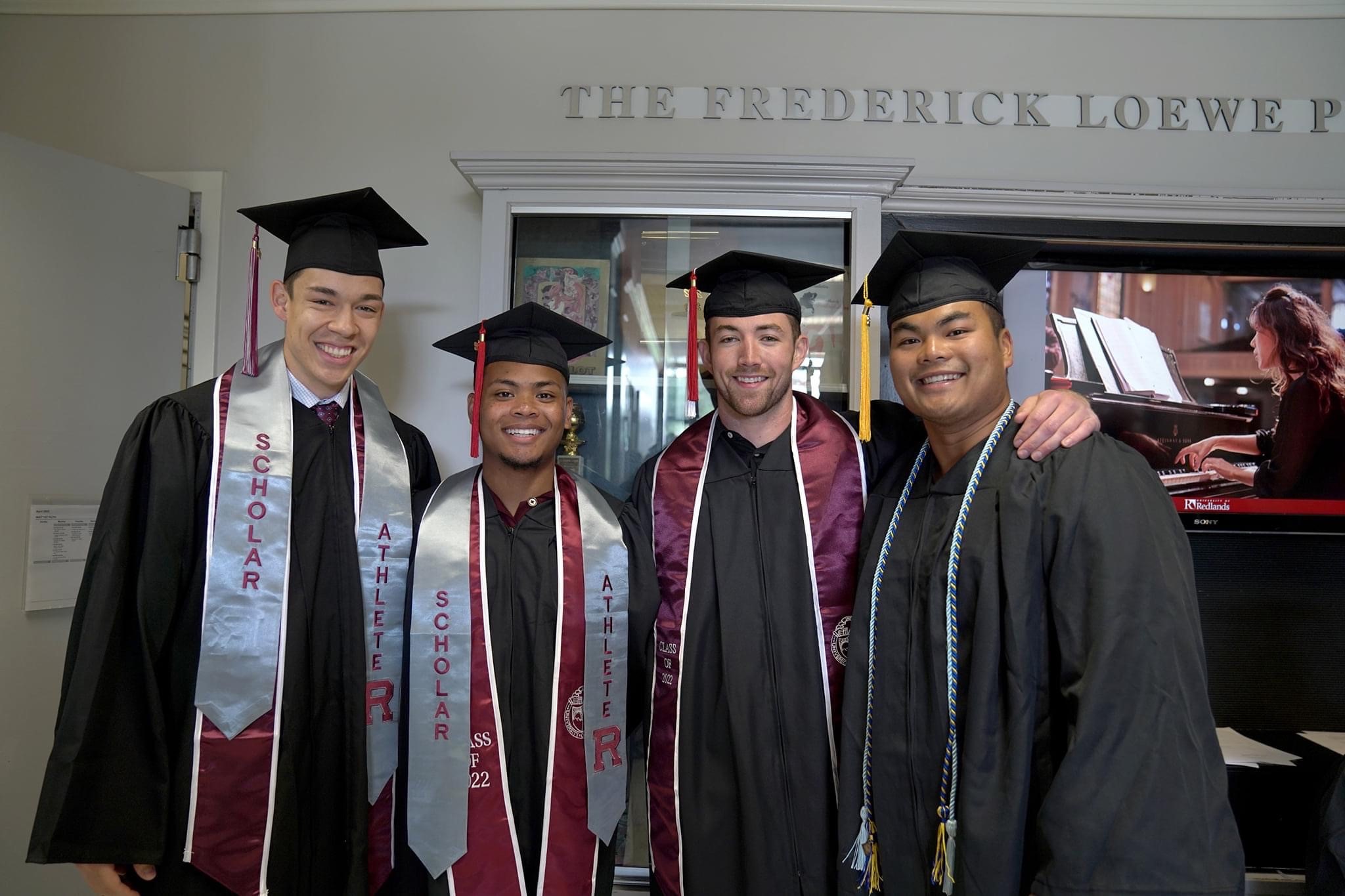 four football players at commencement